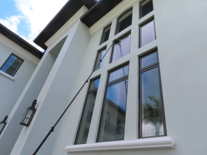 Water-fed pole cleaning a two-story window wall on a Tampa estate