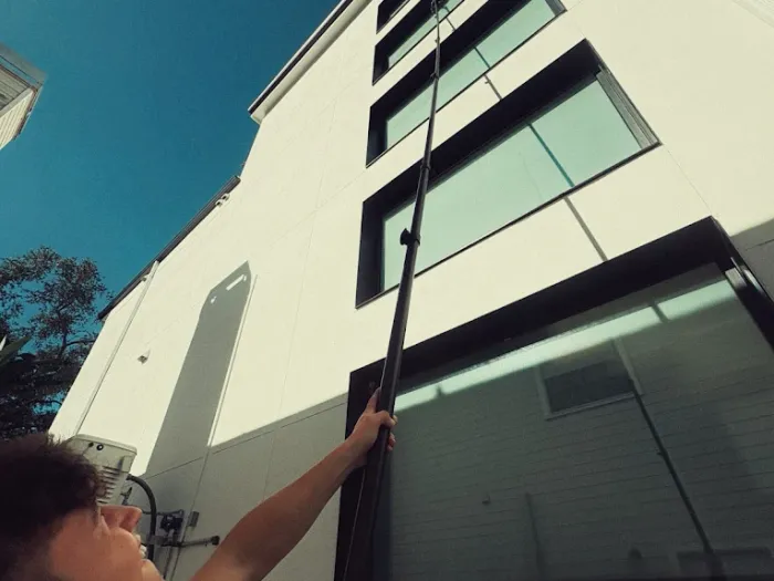 Water-fed pole reaching the upper windows of a modern Tampa home from the ground