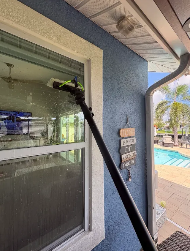 Pure water running down the glass from a water-fed brush at a Tampa waterfront home