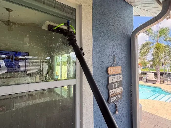 Pure water running down the glass from a water-fed brush at a Tampa waterfront home