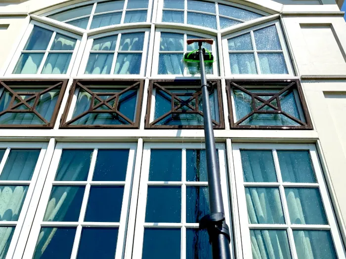 Water-fed pole reaching a two-story arched window façade